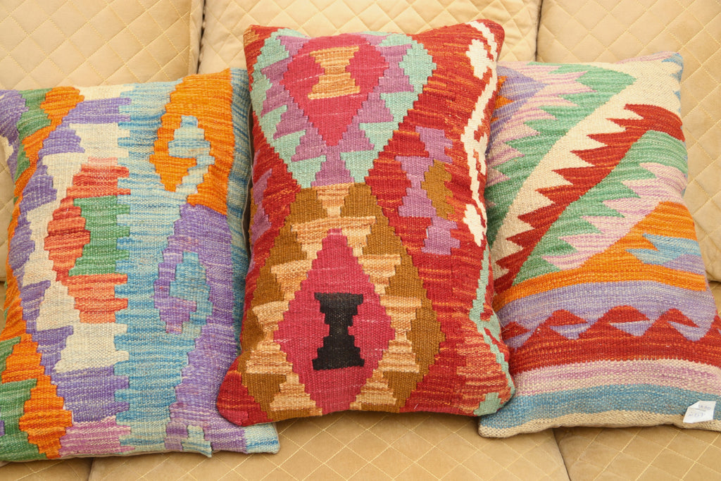 Multicolor geometric wool cushion featuring a vibrant patterned design for luxury home décor.