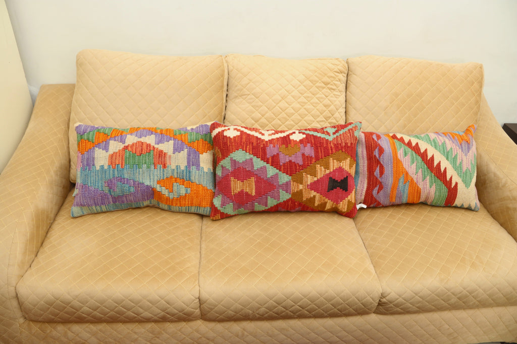 Luxury multicolor geometric wool cushion with a vibrant patterned design for elegant home décor.