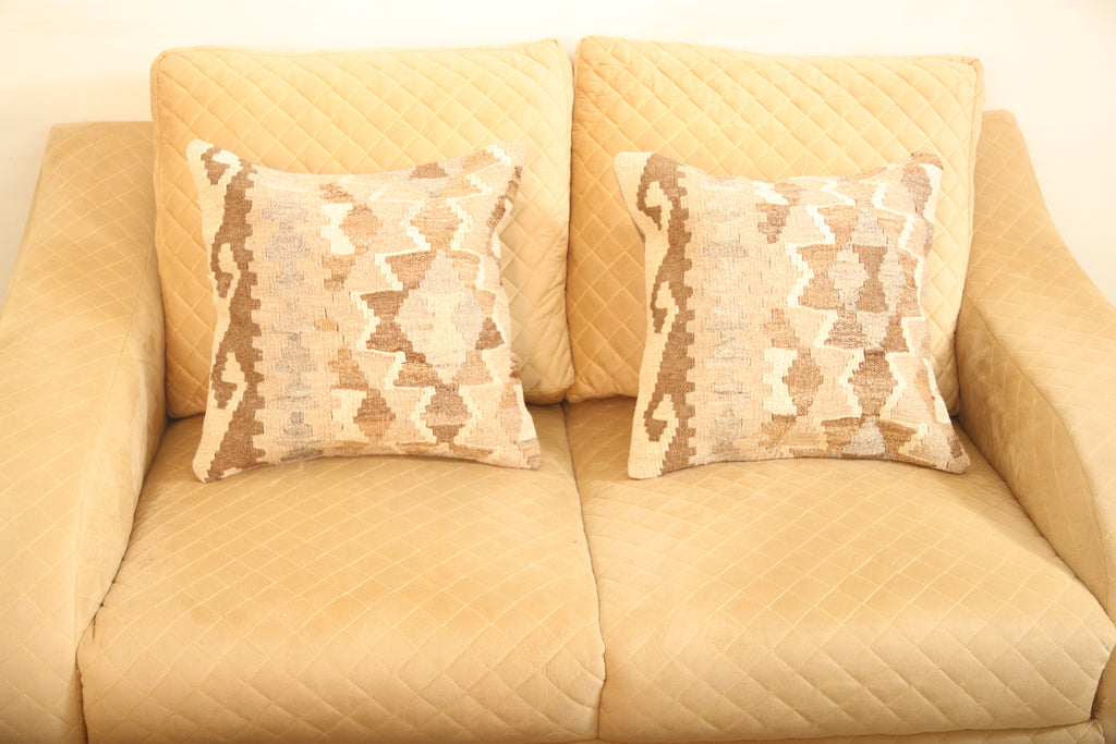 Luxury beige and brown geometric wool square cushion set of two with a traditional patterned design for elegant home décor.