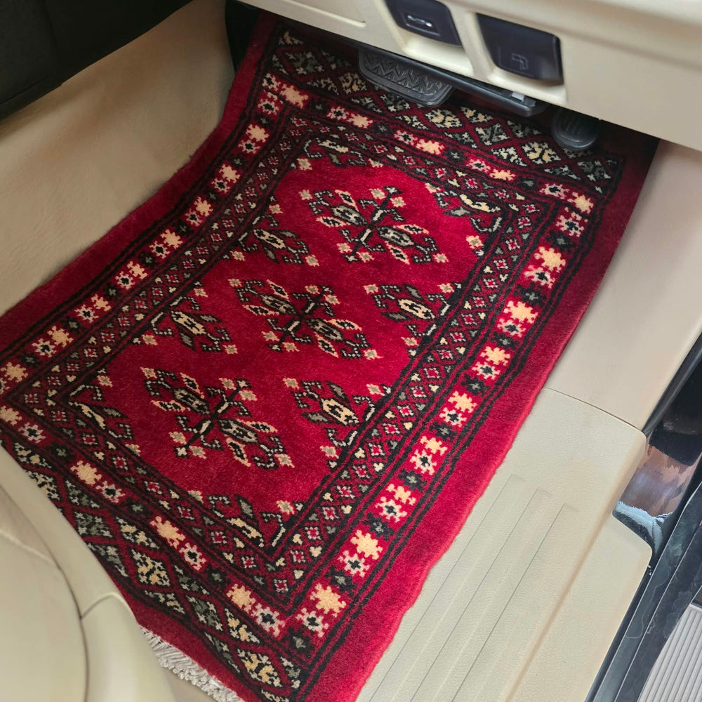 Red handmade cotton wool car mat with an intricate traditional geometric pattern