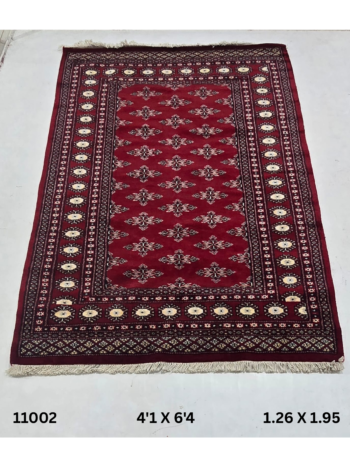 Handmade wool and cotton area rug or runner with repeated geometric Bokhara pattern displayed on floor
