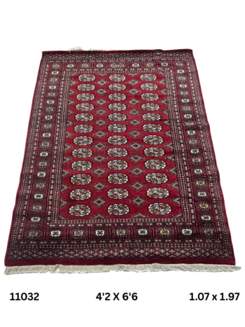 Handmade wool and cotton area rug or runner with repeated geometric Bokhara pattern displayed on floor