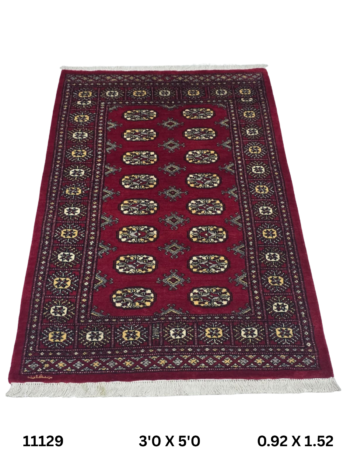 Handmade wool and cotton area rug or runner with repeated geometric Bokhara pattern displayed on floor
