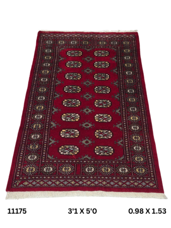 Handmade wool and cotton area rug or runner with repeated geometric Bokhara pattern displayed on floor