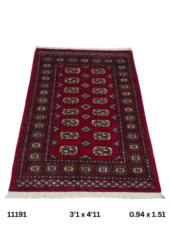Handmade wool and cotton area rug or runner with repeated geometric Bokhara pattern displayed on floor