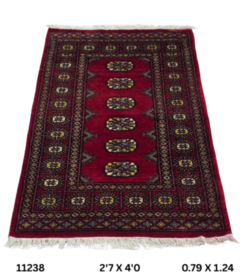 Handmade wool and cotton area rug or runner with repeated geometric Bokhara pattern displayed on floor