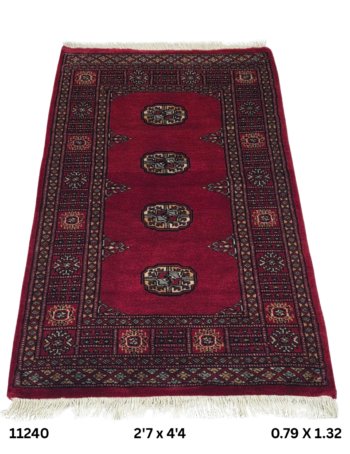 Handmade wool and cotton area rug or runner with repeated geometric Bokhara pattern displayed on floor