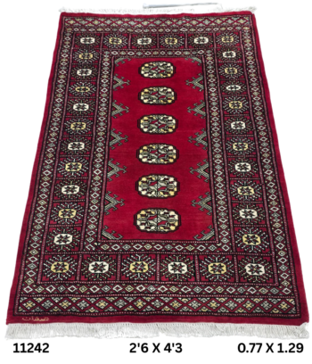 Handmade wool and cotton area rug or runner with repeated geometric Bokhara pattern displayed on floor