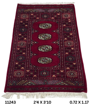 Handmade wool and cotton area rug or runner with repeated geometric Bokhara pattern displayed on floor