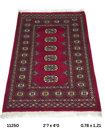 Handmade wool and cotton area rug or runner with repeated geometric Bokhara pattern displayed on floor