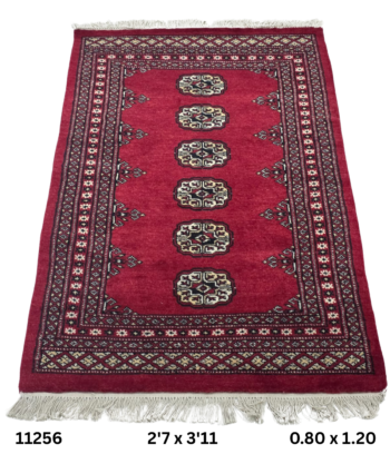 Handmade wool and cotton area rug or runner with repeated geometric Bokhara pattern displayed on floor