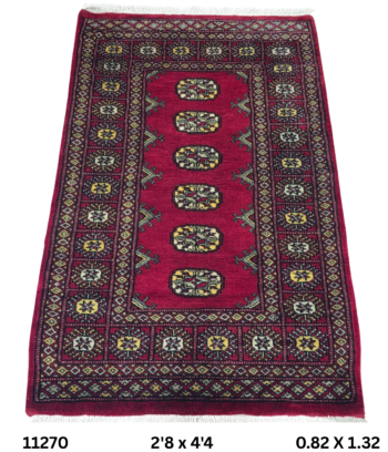 Handmade wool and cotton area rug or runner with repeated geometric Bokhara pattern displayed on floor