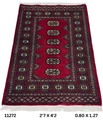 Handmade wool and cotton area rug or runner with repeated geometric Bokhara pattern displayed on floor