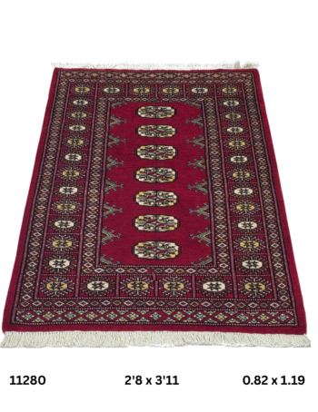 Handmade wool and cotton area rug or runner with repeated geometric Bokhara pattern displayed on floor