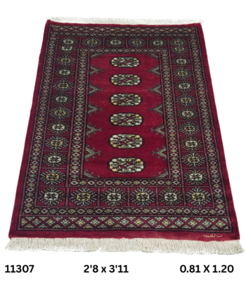 Handmade wool and cotton area rug or runner with repeated geometric Bokhara pattern displayed on floor