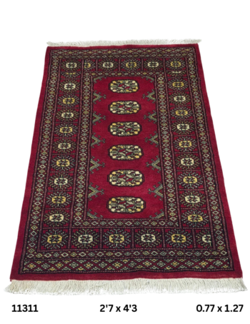 Handmade wool and cotton area rug or runner with repeated geometric Bokhara pattern displayed on floor