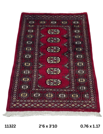 Handmade wool and cotton area rug or runner with repeated geometric Bokhara pattern displayed on floor