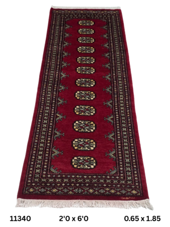 Handmade wool and cotton area rug or runner with repeated geometric Bokhara pattern displayed on floor