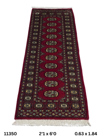 Handmade wool and cotton area rug or runner with repeated geometric Bokhara pattern displayed on floor