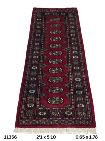 Handmade wool and cotton area rug or runner with repeated geometric Bokhara pattern displayed on floor
