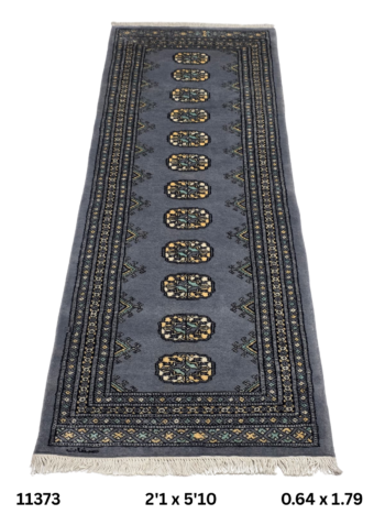 Handmade wool and cotton area rug or runner with repeated geometric Bokhara pattern displayed on floor