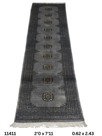 Handmade wool and cotton area rug or runner with repeated geometric Bokhara pattern displayed on floor