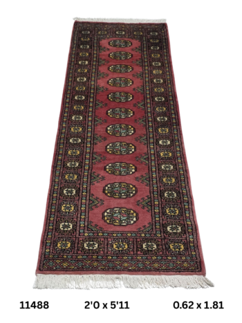 Handmade wool and cotton area rug or runner with repeated geometric Bokhara pattern displayed on floor