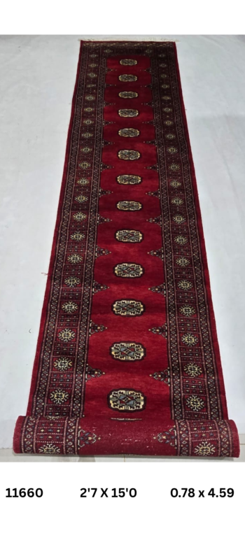 Handmade wool and cotton area rug or runner with repeated geometric Bokhara pattern displayed on floor