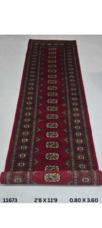 Handmade wool and cotton area rug or runner with repeated geometric Bokhara pattern displayed on floor