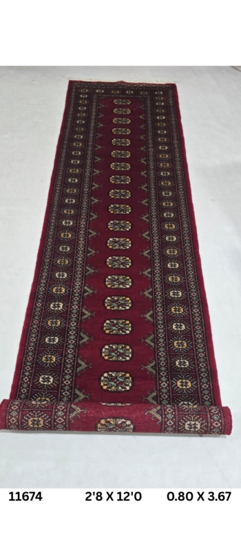 Handmade wool and cotton area rug or runner with repeated geometric Bokhara pattern displayed on floor