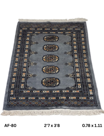 Handmade wool and cotton area rug or runner with repeated geometric Bokhara pattern displayed on floor