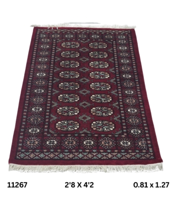 Handmade wool and cotton area rug or runner with repeated geometric Bokhara pattern displayed on floor