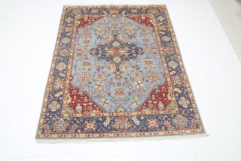 Handmade wool and cotton area rug or runner with classic floral Heriz pattern displayed on floor