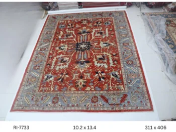 Handmade wool and cotton area rug or runner with classic floral Heriz pattern displayed on floor