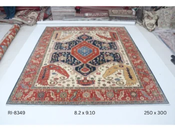Handmade wool and cotton area rug or runner with classic floral Heriz pattern displayed on floor