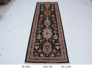 Handmade wool and cotton area rug or runner with classic floral Heriz pattern displayed on floor