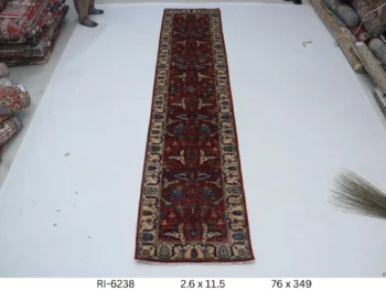 Handmade wool and cotton area rug or runner with classic floral Heriz pattern displayed on floor