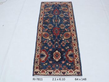 Handmade wool and cotton area rug or runner with classic floral Heriz pattern displayed on floor