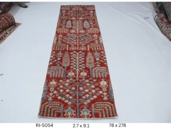 Handmade wool and cotton area rug or runner with classic floral Heriz pattern displayed on floor