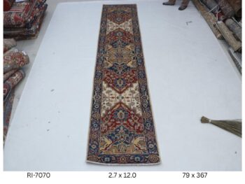 Handmade wool and cotton area rug or runner with classic floral Heriz pattern displayed on floor