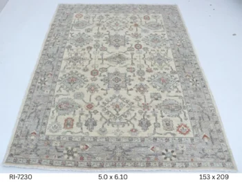 Handmade wool and cotton area rug or runner with classic floral Heriz pattern displayed on floor