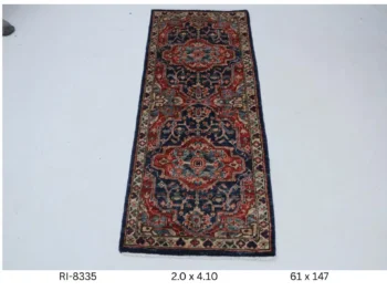 Handmade wool and cotton area rug or runner with classic floral Heriz pattern displayed on floor