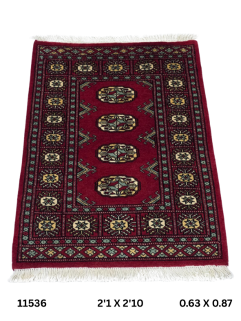 Handmade wool and cotton area rug or runner with repeated geometric Bokhara pattern displayed on floor