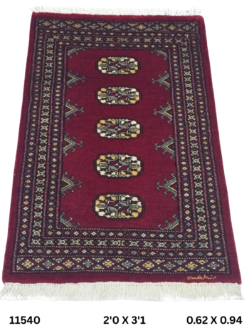 Handmade wool and cotton area rug or runner with repeated geometric Bokhara pattern displayed on floor