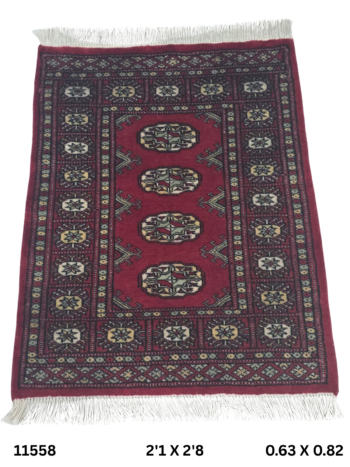 Handmade wool and cotton area rug or runner with repeated geometric Bokhara pattern displayed on floor