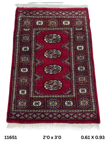 Handmade wool and cotton area rug or runner with repeated geometric Bokhara pattern displayed on floor