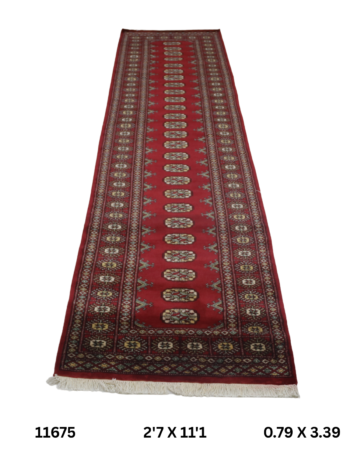 Handmade wool and cotton area rug or runner with repeated geometric Bokhara pattern displayed on floor