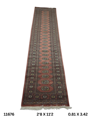 Handmade wool and cotton area rug or runner with repeated geometric Bokhara pattern displayed on floor