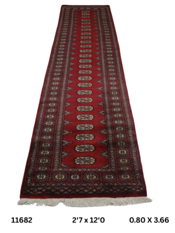 Handmade wool and cotton area rug or runner with repeated geometric Bokhara pattern displayed on floor