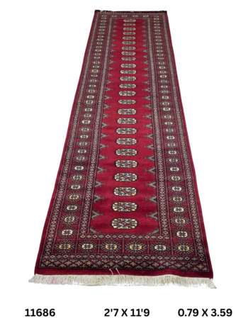 Handmade wool and cotton area rug or runner with repeated geometric Bokhara pattern displayed on floor